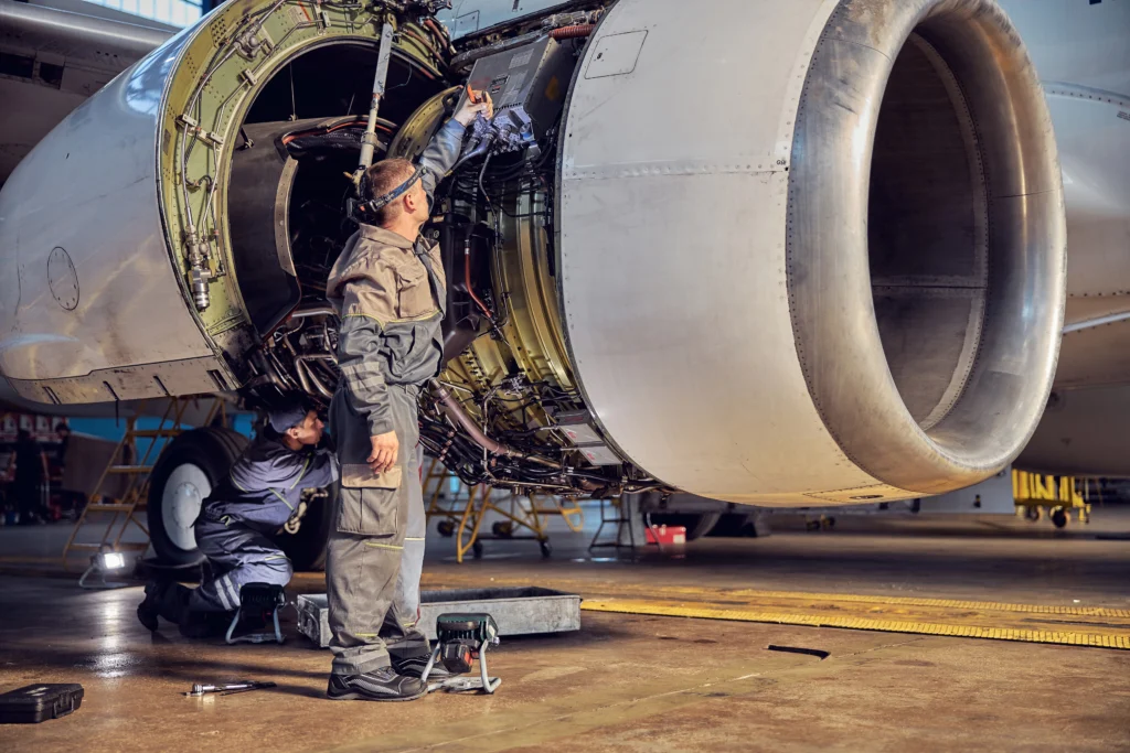 Aviation MRO team repairing an aircraft engine at a hangar.